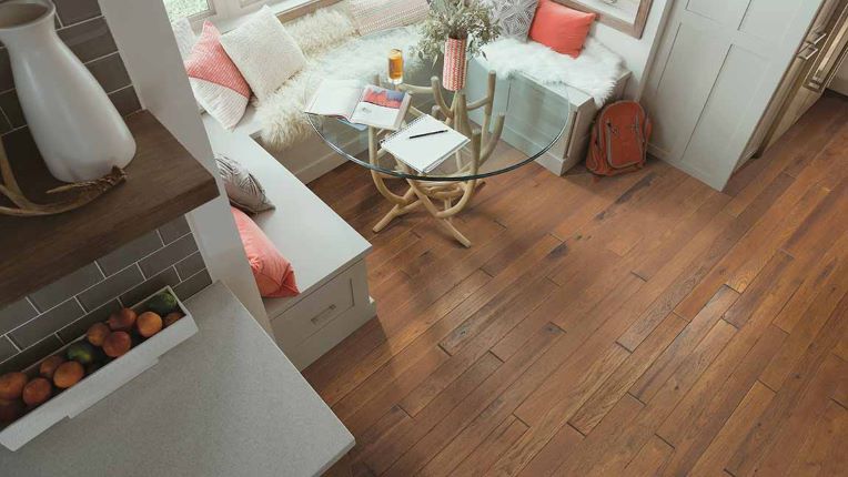 dark toned hardwood flooring in a dining area with a cozy breakfast nook